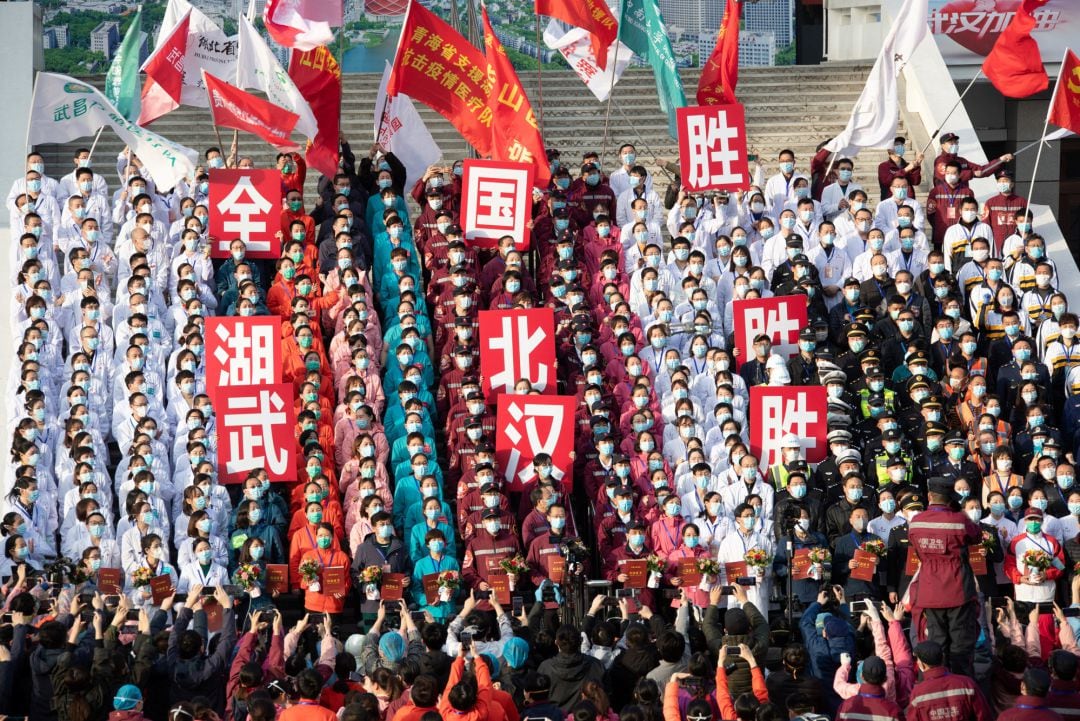 Trabajadores de los hospitales levantados en Wuhan por el coronavirus durante la ceremonia de cierre de los centros sanitarios porque ya no son necesarios. 