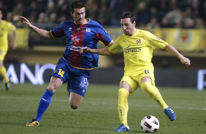 El centrocampista del Villarreal Santi Cazorla trata de regatear al mediocentro del Levante UD Xavier Torres durante el partido correspondiente a la 22ª jornada de la Liga disputado en El Madrigal.