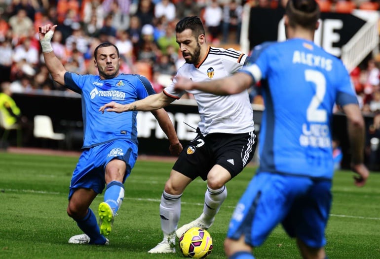 Getafe&#039;s Algerian midfielder Medhi Lacen (L) vies with Valencia&#039;s forward Alvaro Negredo during the Spanish league football match Valencia CF vs Getafe CF at Mestalla stadium in Valencia on February 15, 2015. AFP PHOTO / JOSE JORDAN