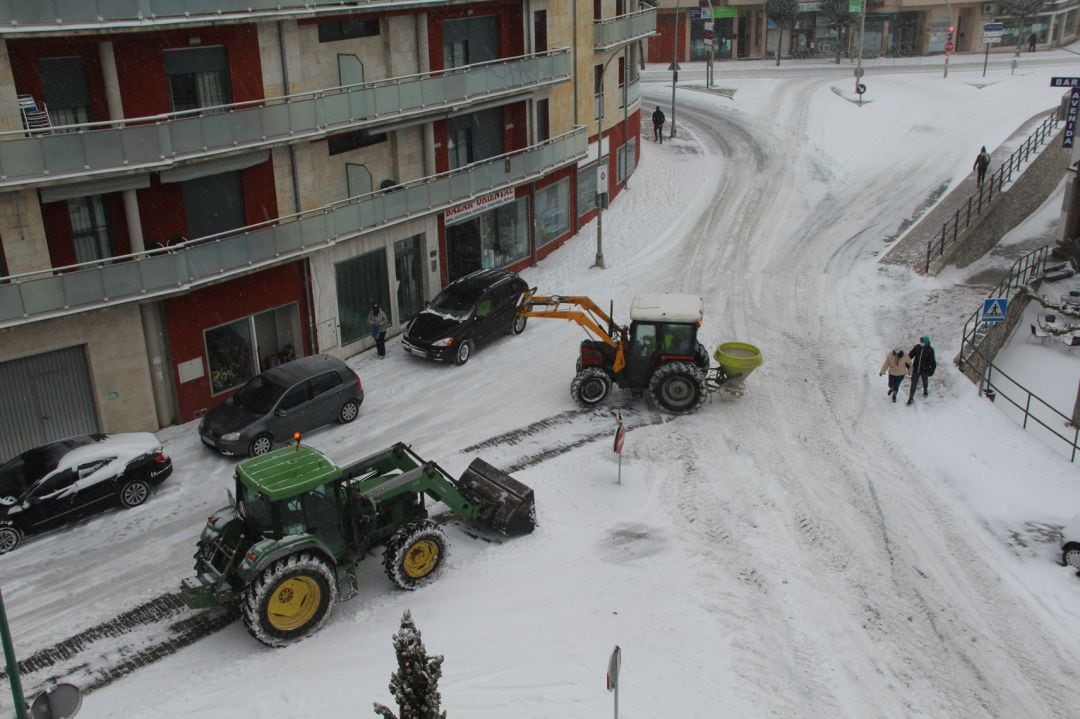 Un tractor retira la nieve de la calzada en el centro de Cuéllar mientras otro espera para esparcir sal