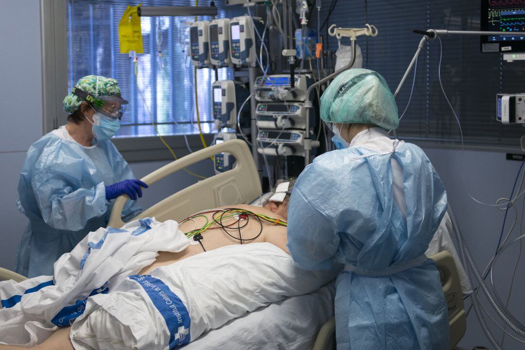 Personal sanitario atendiendo a un paciente ingresado en la UCI para enfermos de coronavirus