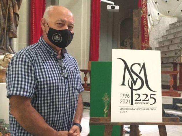 El presidente de la Cofradía de lso Santos Patronos ante el logo del 225 aniversario