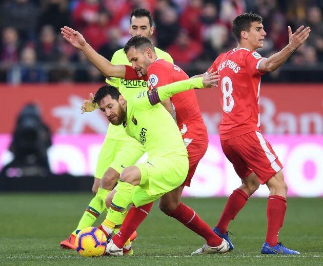 Messi en una disputa con Stuani durante el partido