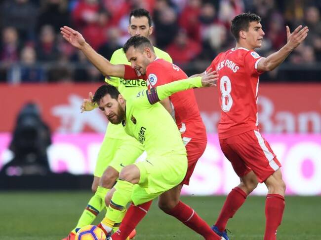 Messi en una disputa con Stuani durante el partido