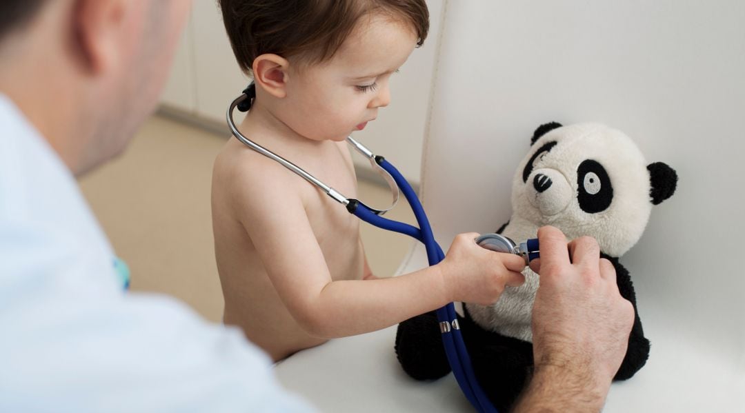 Un pediatra en consulta con un niño