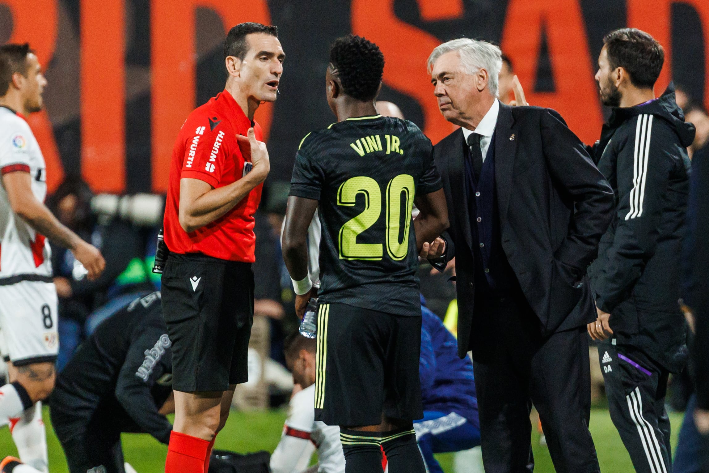 Vinicius habla con Martínez Munuera, ante la atenta mirada de Ancelotti, en el Rayo - Real Madrid, el pasado lunes.