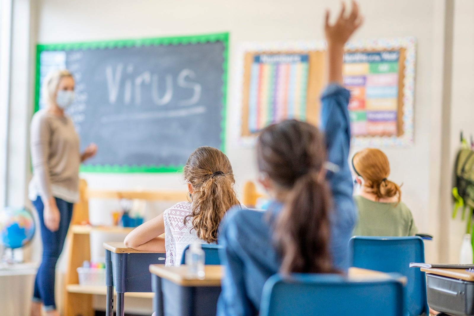 Una alumna levanta la mano para pedir turno durante una clase en un aula