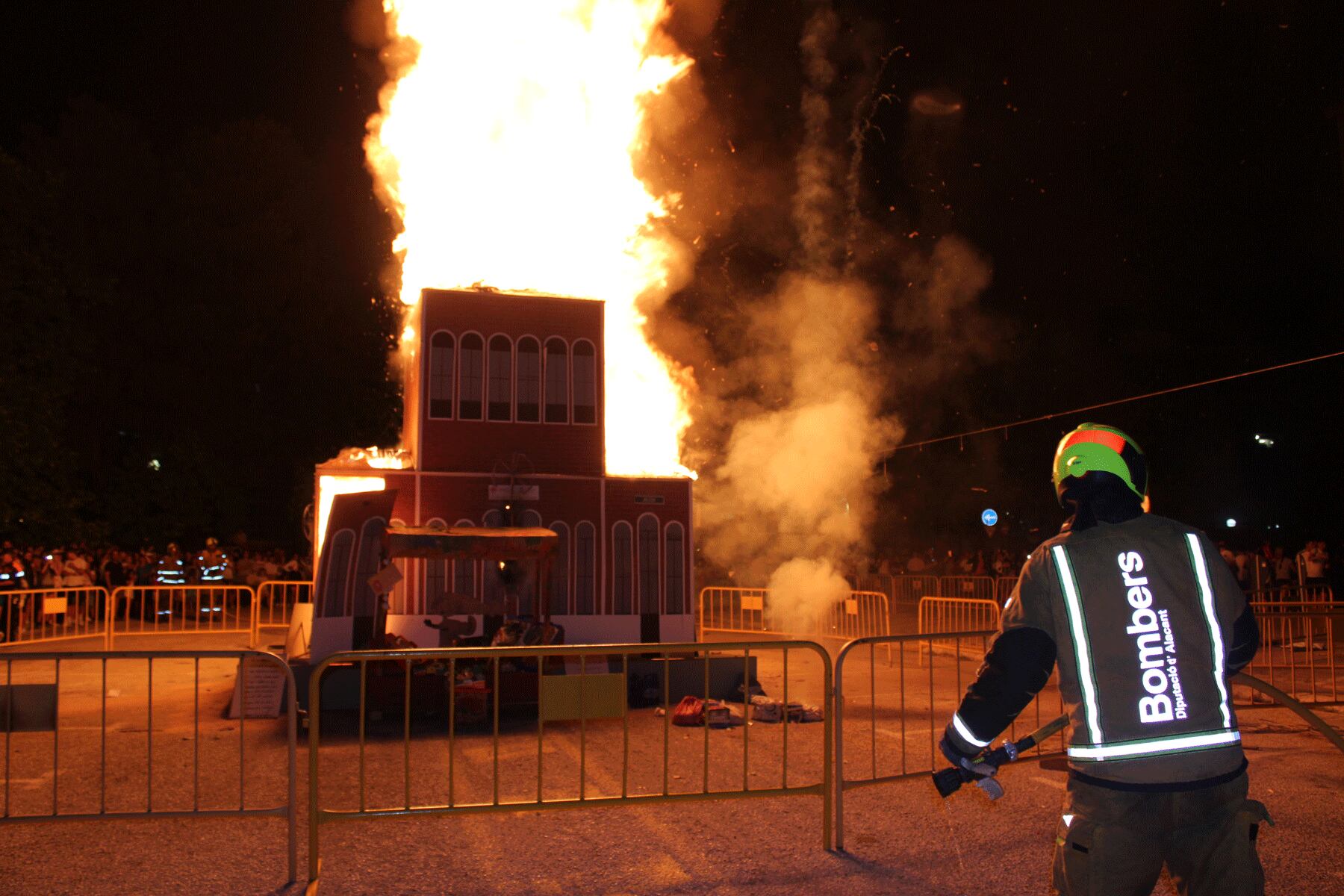 Imagen de la Foguera de la Zona Nord quemándose con la presencia de los bomberos