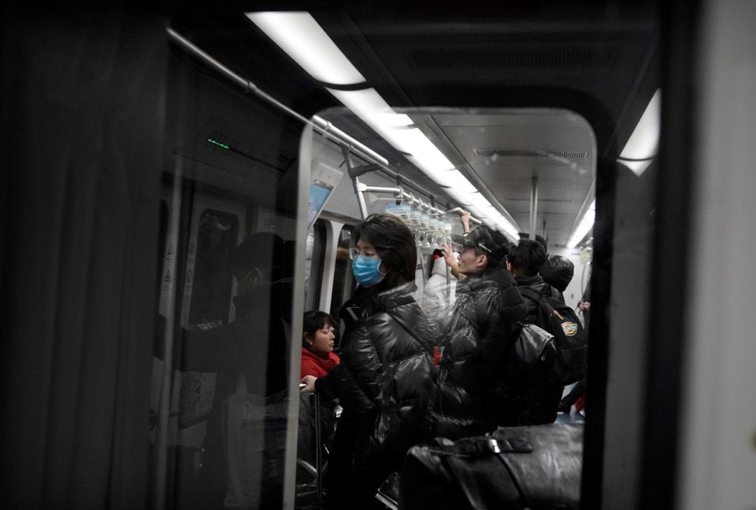 Una mujer con una máscara es retratada en el metro de Beijing