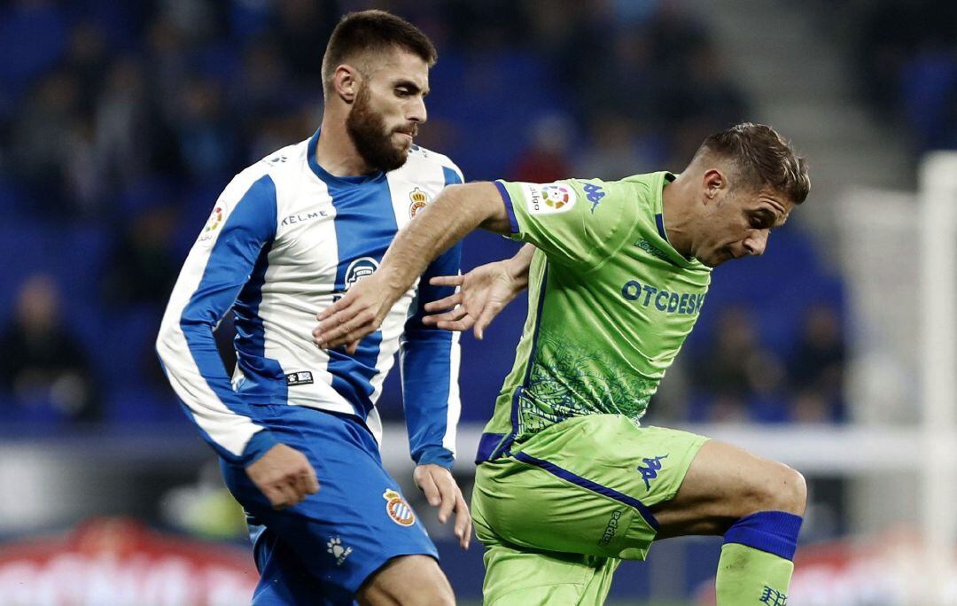 El centrocampista del RCD Espanyol, David López, lucha por el balón ante el centrocampista del Real Betis, Joaquín Sánchez.