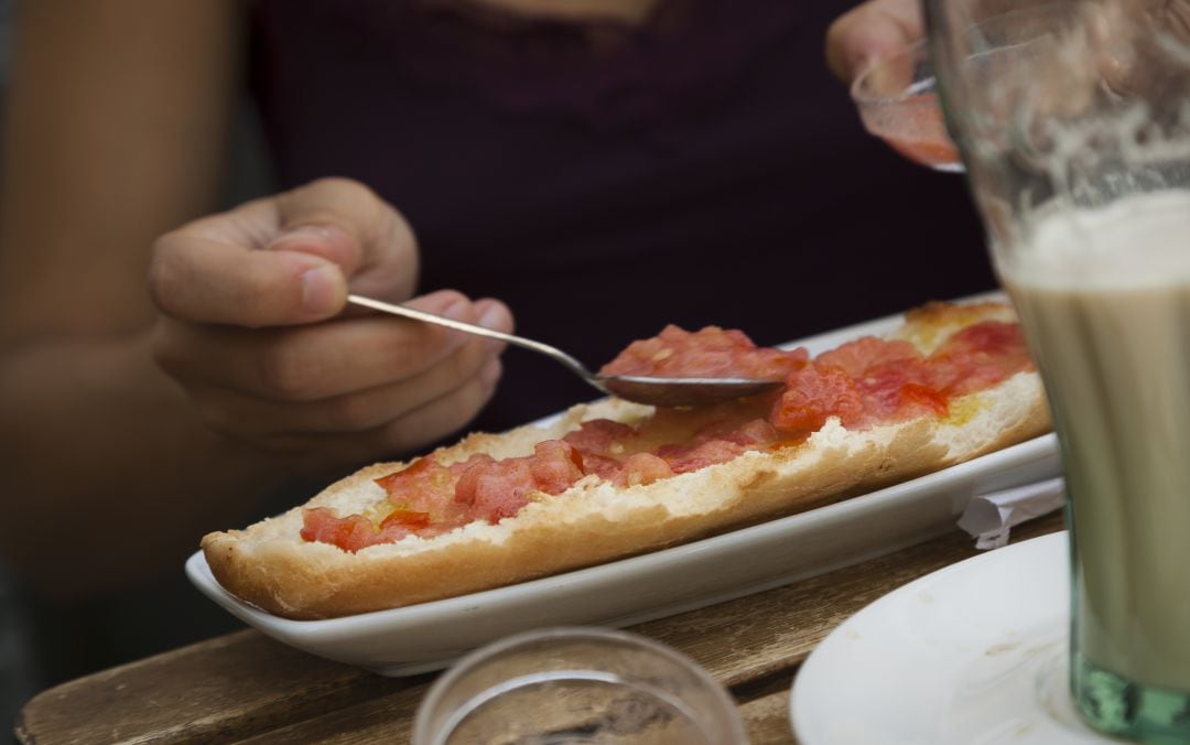 El orden correcto en el que se deben poner el aceite y el tomate en las tostadas.