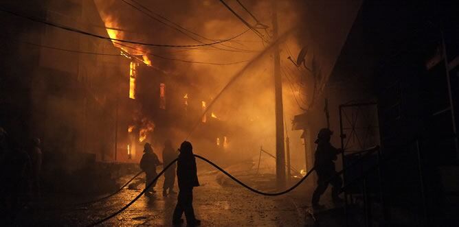 Bomberos intenta controlar un incendio en uno de los cerros de la ciudad de Valparaíso (Chile).