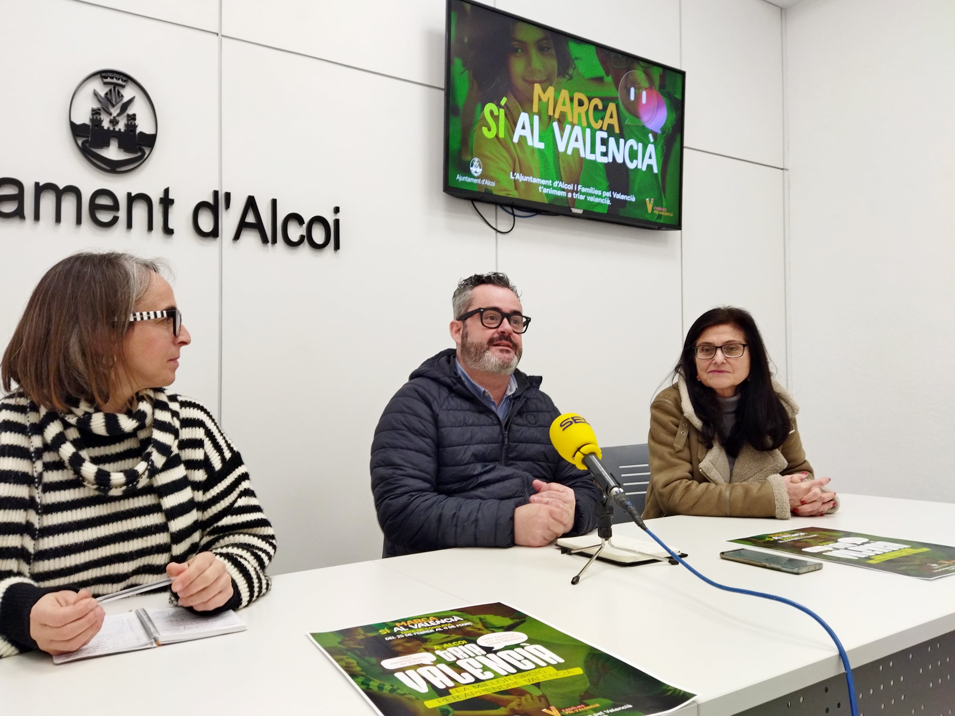 Rebeca Sanjuán, representante de Famílies pel valencià; Raül Llopis, edil de Normalització Lingüística, y Dolors Sanchis, técnica del Gabinet de Normalització Lingüística, presentan la campaña para invitar a marcar &#039;sí al valencià&#039; en la consulta convocada por la Conselleria de Educación.