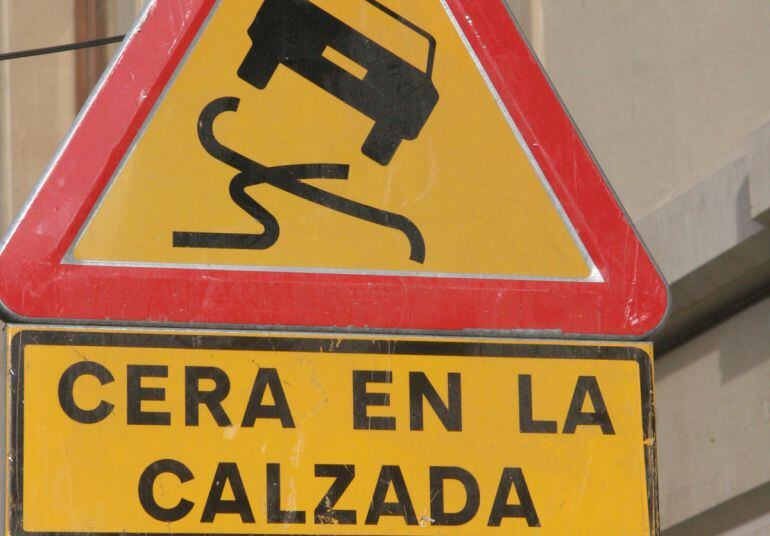 Señal de tráfico advirtiendo del peligro de cera en la calzada