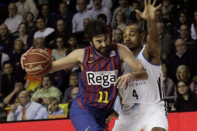 El escolta del F.C. Barcelona Juan Carlos Navarro entra a canasta ante el base estadounidense del Real Madrid Dontaye Draper durante el partido de la decimoquinta jornada de Liga ACB