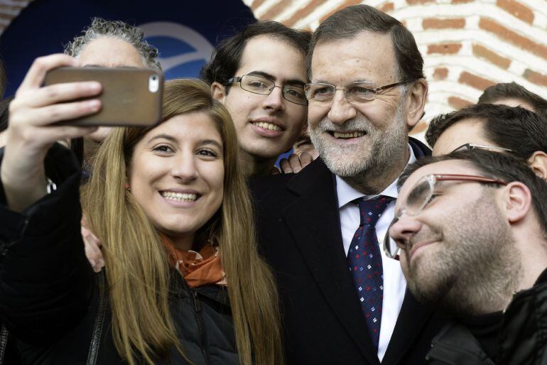 El presidente del Gobierno, Mariano Rajoy, se fotografía con un grupo de jóvenes tras su intervención hoy en un mitin organizado por el PP en la localidad vallisoletana de Olmedo