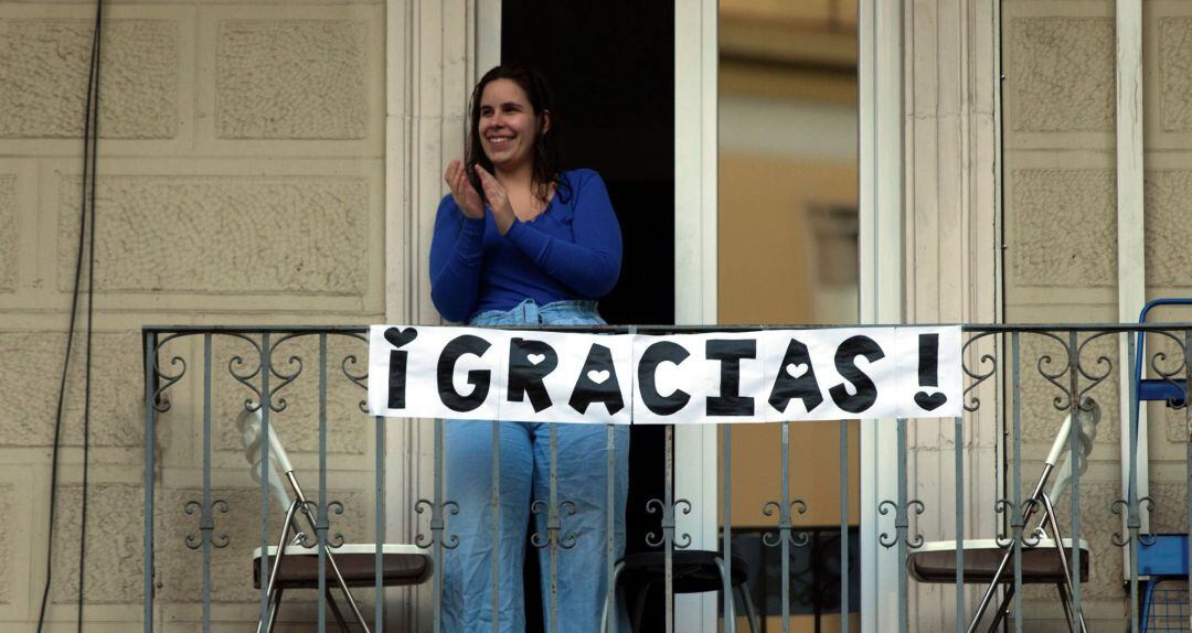 Una vecina aplaude desde un balcón para dar ánimos a todos los que trabajan en la crisis del coronavirus