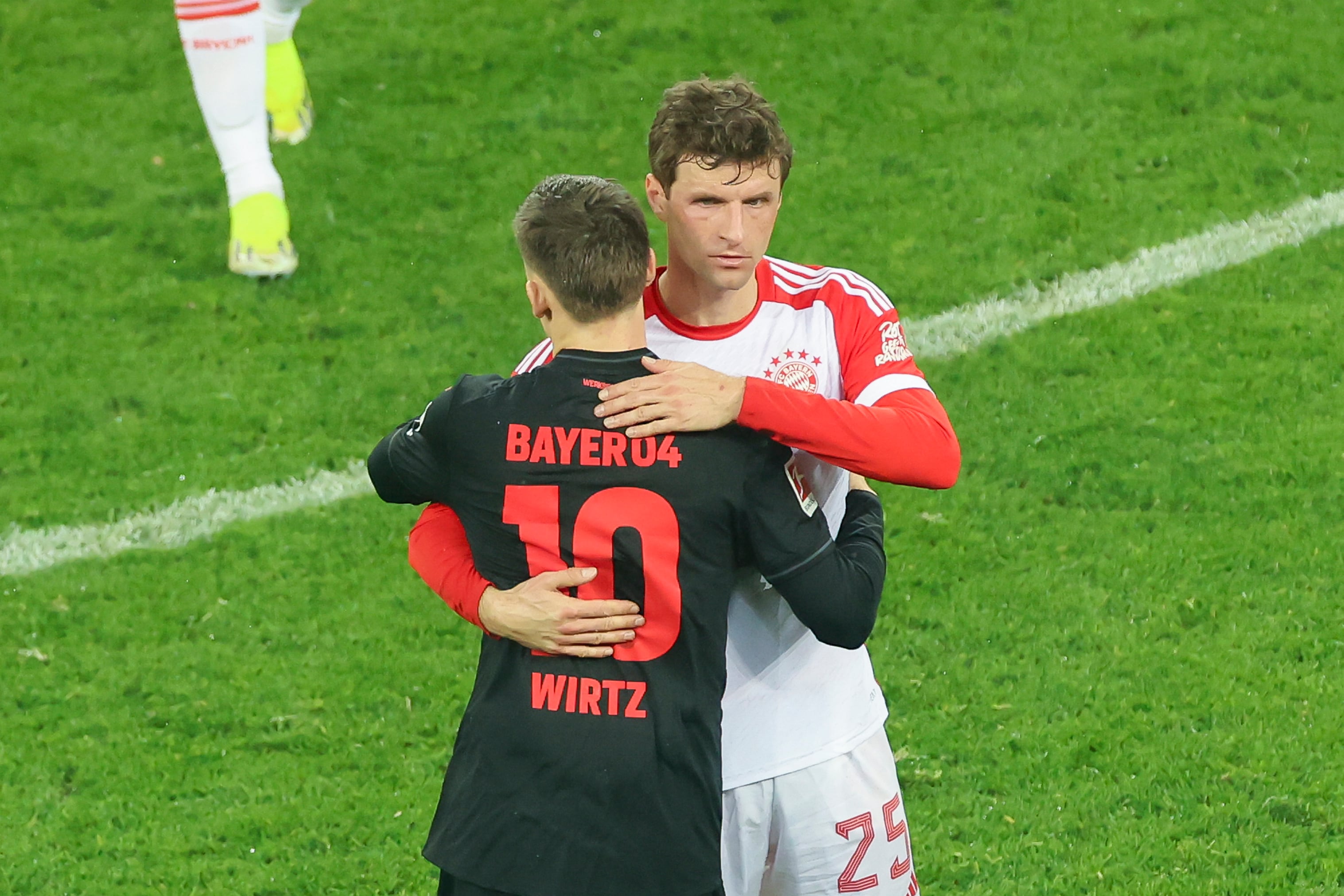 Florian Wirtz y Thomas Müller se saludan tras un enfrentamiento en Bundesliga