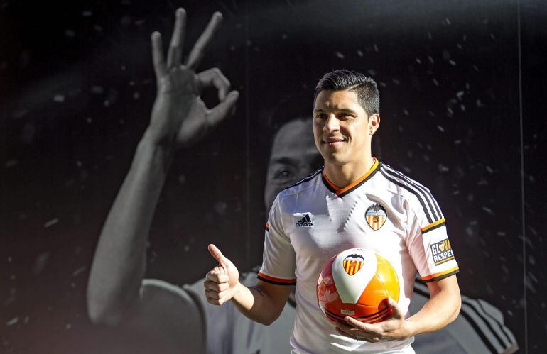 GRA113. VALENCIA, 02/01/2015.- El centrocampista argentino Enzo Pérez, que llega al Valencia traspasado por el Benfica portugués a cambio de veinticinco millones de euros, posa durante su presentación esta tarde ante cerca de 8.000 aficionados en el estadio de Mestalla. EFE/Manuel Bruque