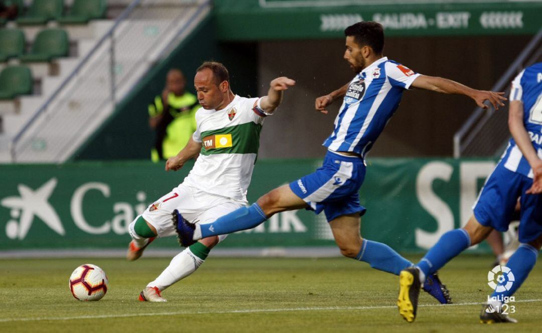 El capitán del Elche Nino intenta rematar ante un jugador del Deportivo