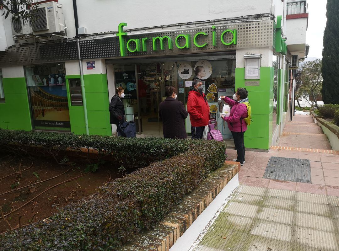 Varios vecinos esperan su turno para acceder a una farmacia en el barrio San Rafael