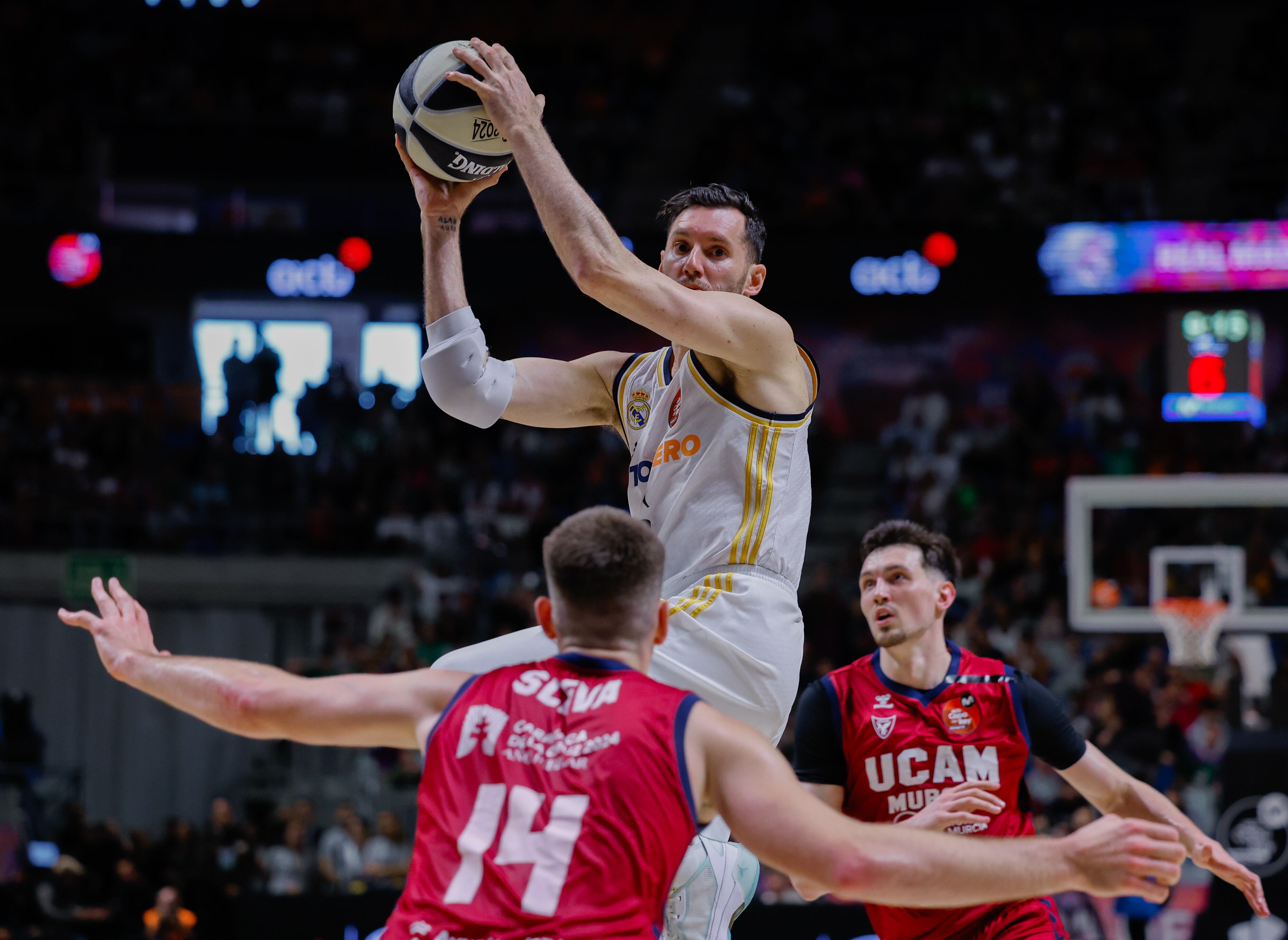 Rudy Fernández pelea el balón con dos jugadores del UCAM Murcia