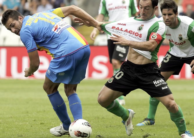 El capitán del Racing de Santander Pedro Munitis disputa un balón ante el centrocampista del Levante Xavi Torres durante el encuentro correspondiente a la tercera jornada de la Liga de Primera División 2011-12