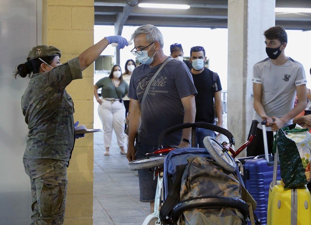Una enfermera del Ejército toma la temperatura a los pasajeros del barco procedente de Málaga durante un control sanitario a su llegada a Melilla este viernes