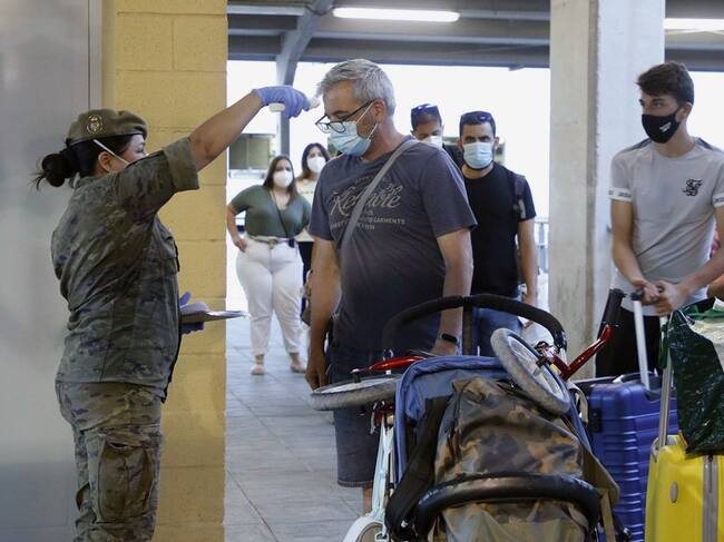 Una enfermera del Ejército toma la temperatura a los pasajeros del barco procedente de Málaga durante un control sanitario a su llegada a Melilla este viernes