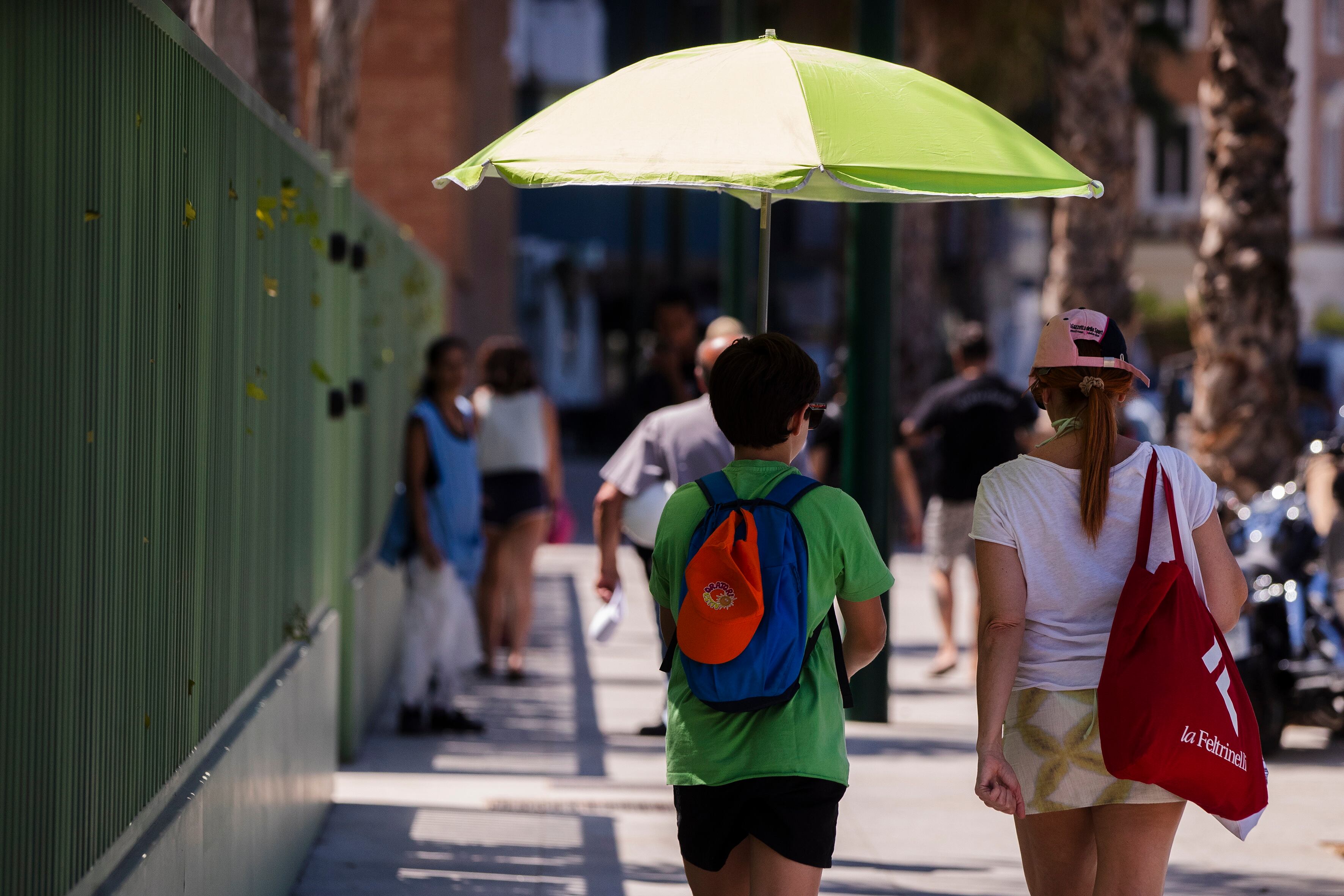 GRAFAND4337. MÁLAGA, 01/08/2023.- Dos personas caminan hacia la playa de la Malagueta donde las temperaturas alcanzan los 35 grados de calor hoy en Málaga. EFE/Jorge Zapata
