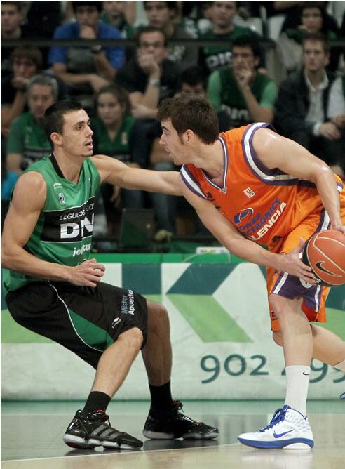 El alero Víctor Claver, del Valencia (d), trata de avanzar con la pelota bajo la defensa del también alero del Joventut Pere Tomàs (i), durante el partido correspondiente a la quinta jornada de la Liga ACB que ambos equipos han disputado esta tarde en el pabellón Olímpico de Badalona.