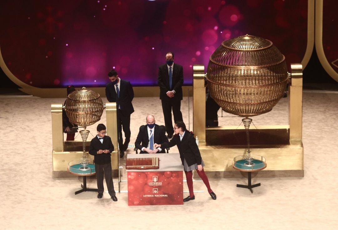 Dos de los niños de la residencia de San Ildefonso Salvador Constantin Roaan y Noura Akrouh cantan alguno de los premios durante la celebración del Sorteo Extraordinario de la Lotería de Navidad 2020 en el Teatro Real de Madrid