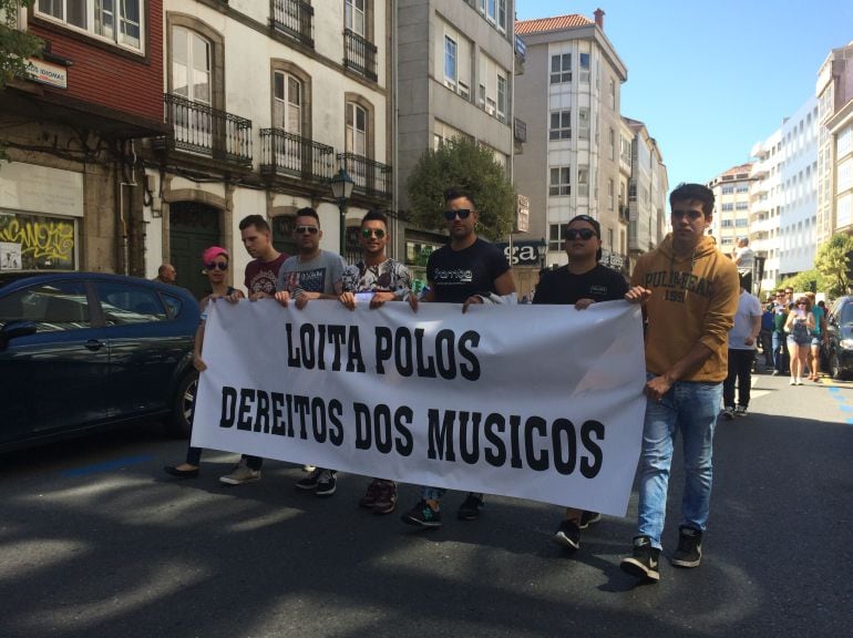 Un grupo de músicos sostiene una pancarta durante la manifestación por las calles del centro de Santiago