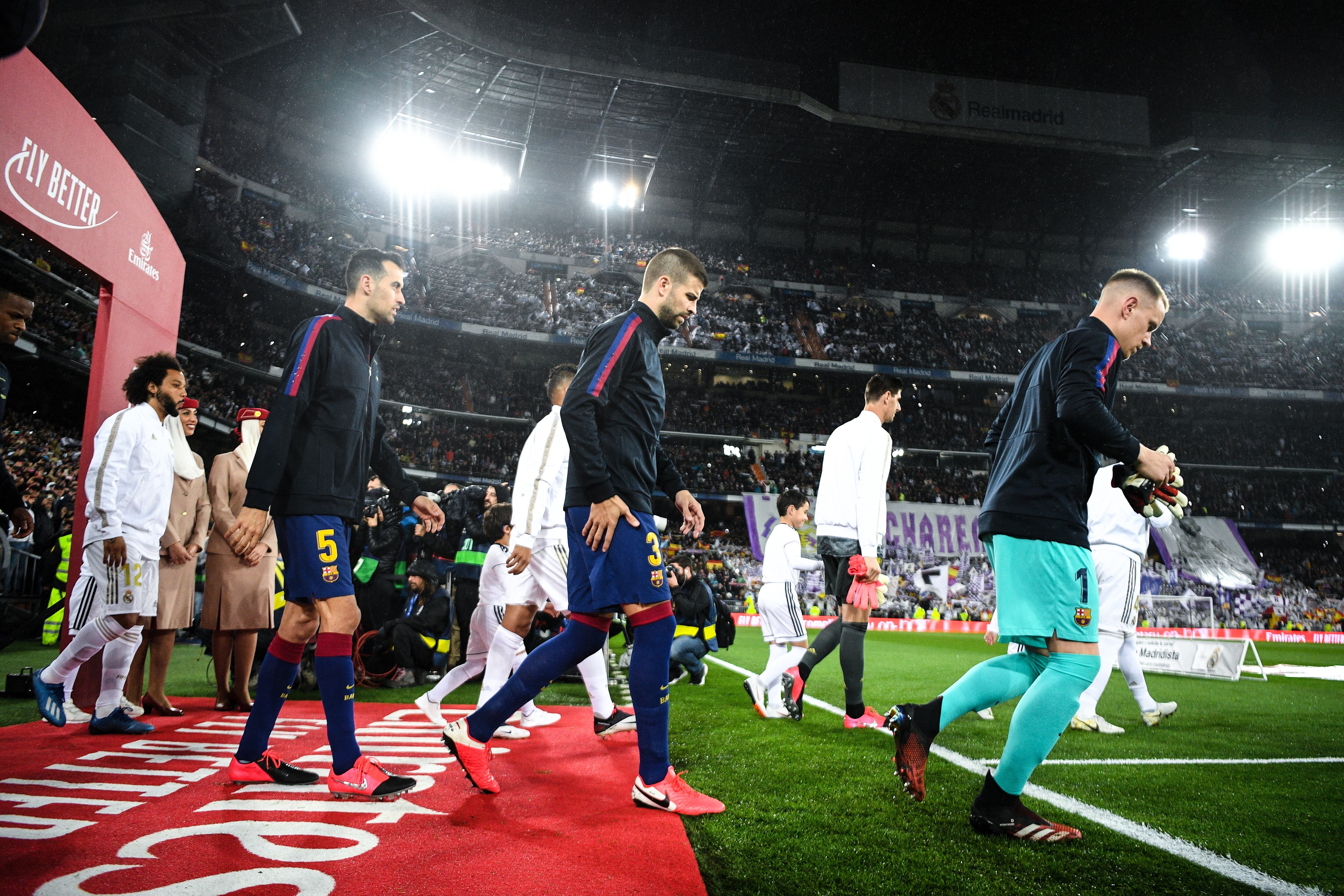 MADRID, SPAIN - MARCH 01: Nelson Semedo, Gerard Pique and Sergio Busquets of FC Barcelona walk onto the pitch during the Liga match between Real Madrid CF and FC Barcelona at Estadio Santiago Bernabeu on March 01, 2020 in Madrid, Spain. (Photo by David Ramos/Getty Images)