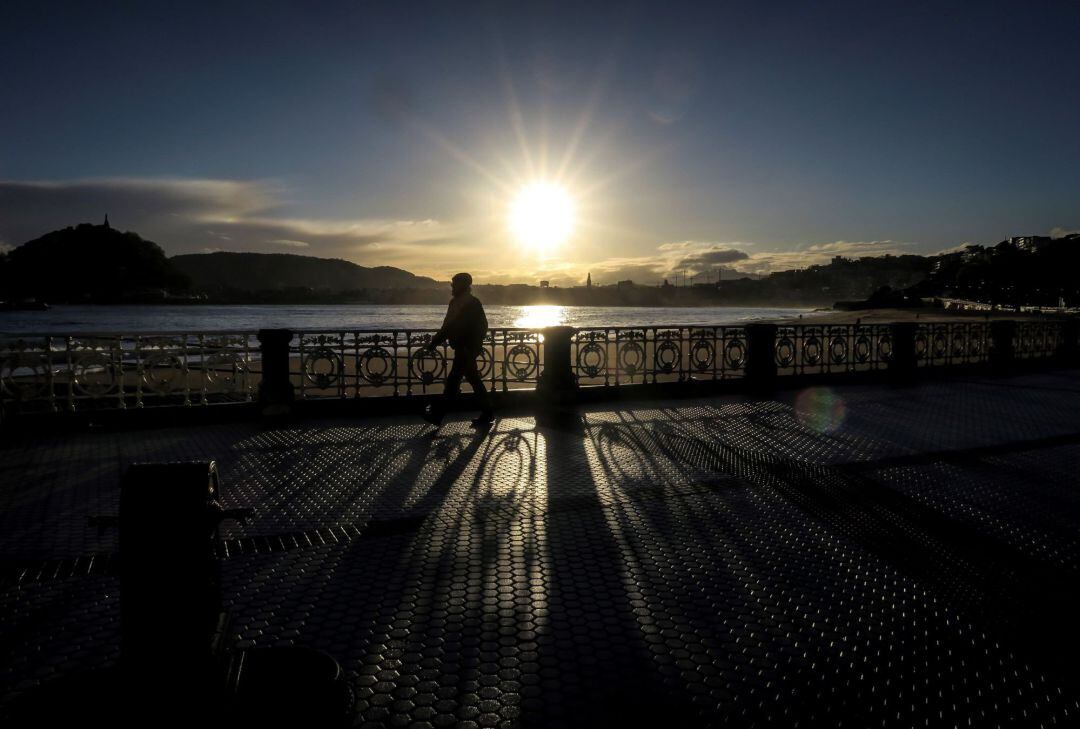 Un hombre pasea junto a la playa de Ondarreta de San Sebastián,