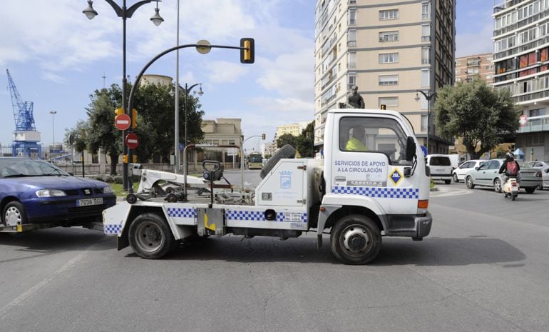 Una grúa municipal de Málaga retirando uno de los vehículos en la ciudad