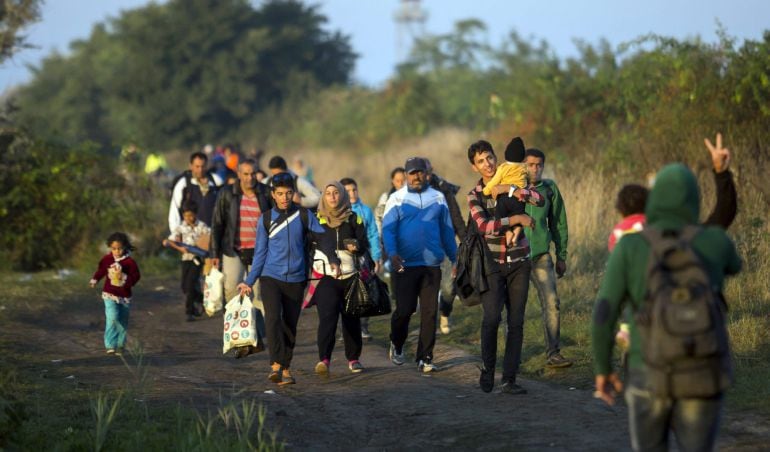 Refugiados caminan por las vías del tren de Horgos a Szeged cerca de Rozke en Hungría.