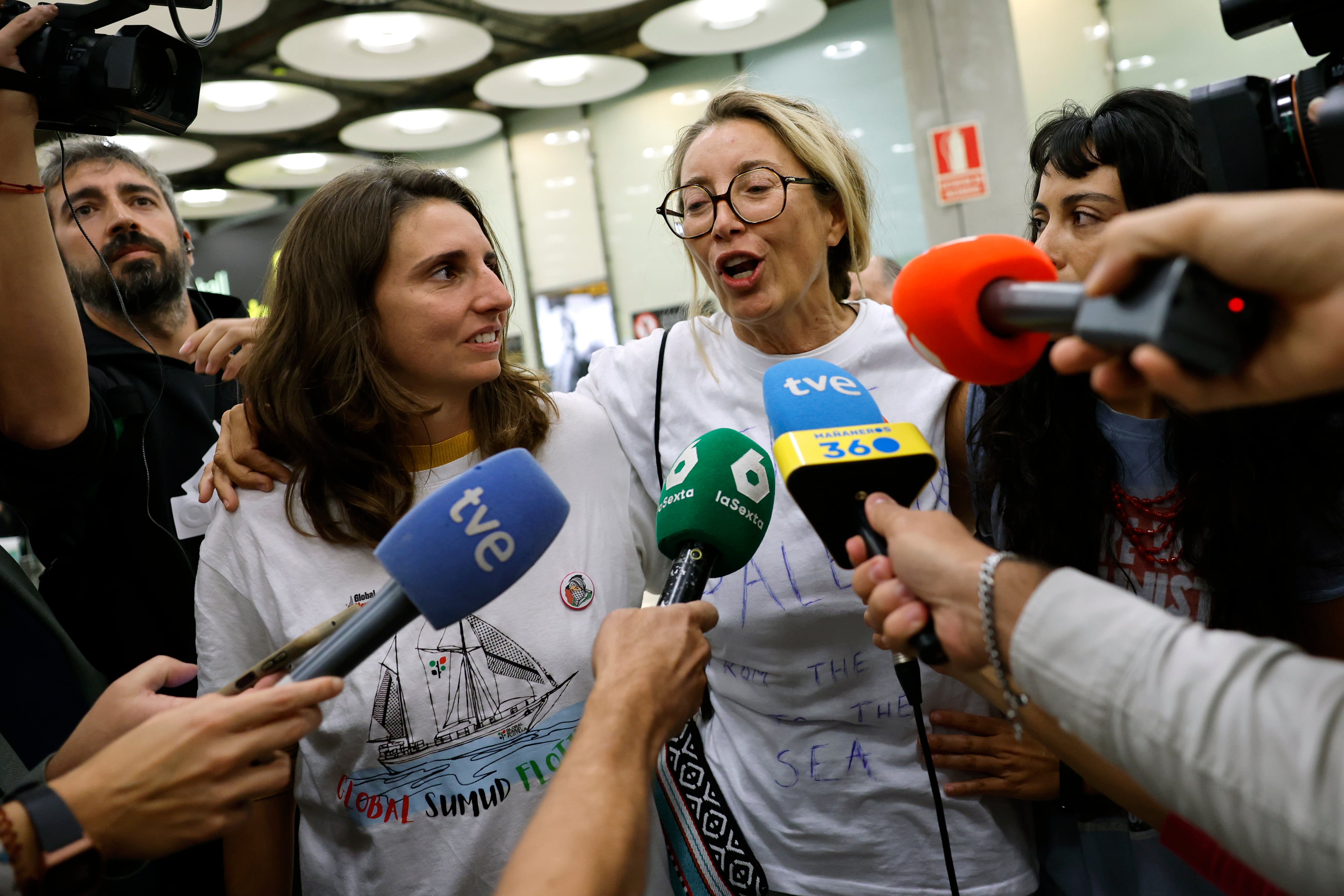 MADRID, 13/10/2025.- La activista mallorquina miembro de la Flotilla Global Sumud Reyes Rigo (c) atiende a la prensa a su llegada al aeropuerto Adolfo Suárez Madrid-Barajas este lunes. Los cinco últimos miembros españoles de las flotillas humanitarias rumbo a Gaza interceptadas este mes por Israel que permanecían en este país han llegado en la mañana de este lunes al aeropuerto Adolfo Suárez Madrid-Barajas en un vuelo procedente de Catar, a donde fueron llevados desde Jordania. EFE/ Mariscal