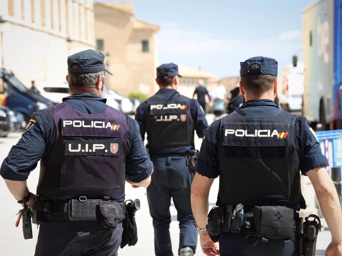 Agentes de la Policía Nacional de espaldas.