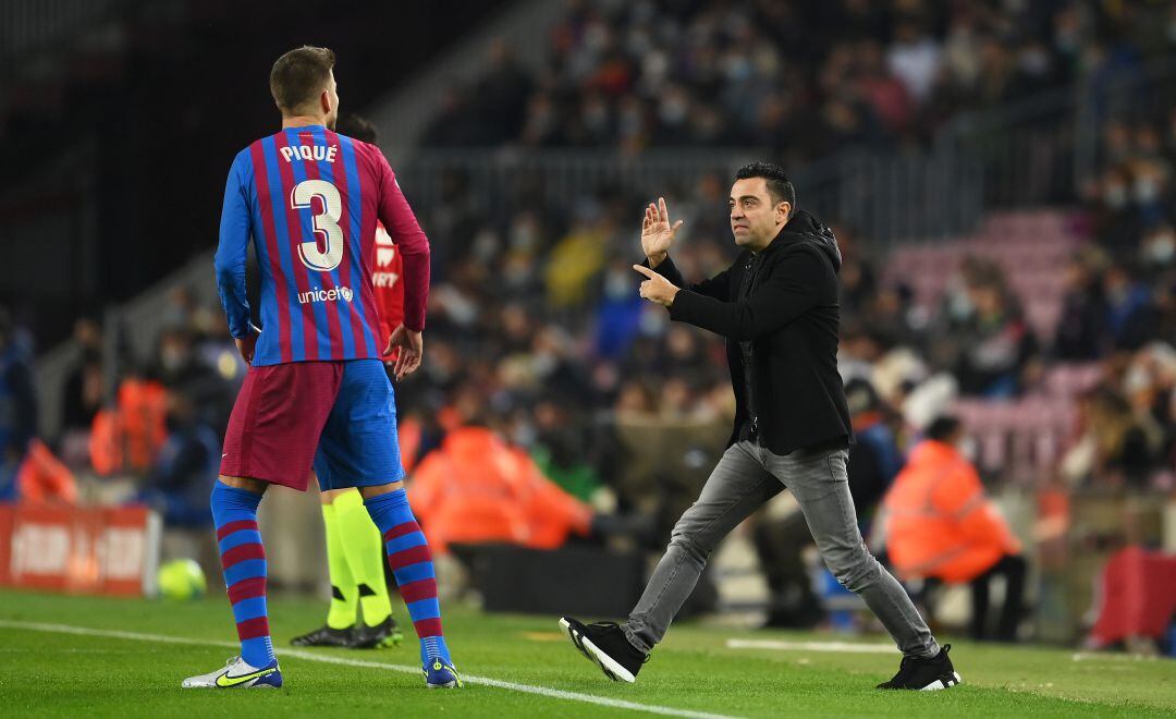 Xavi da órdenes a Gerard Piqué durante un partido de liga