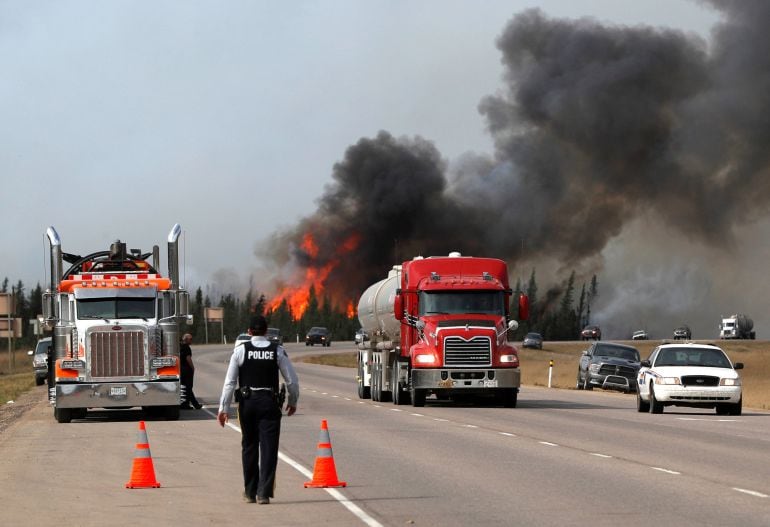 Los vehículos con material peligroso se alejan de las llamas cerca de Fort McMurray