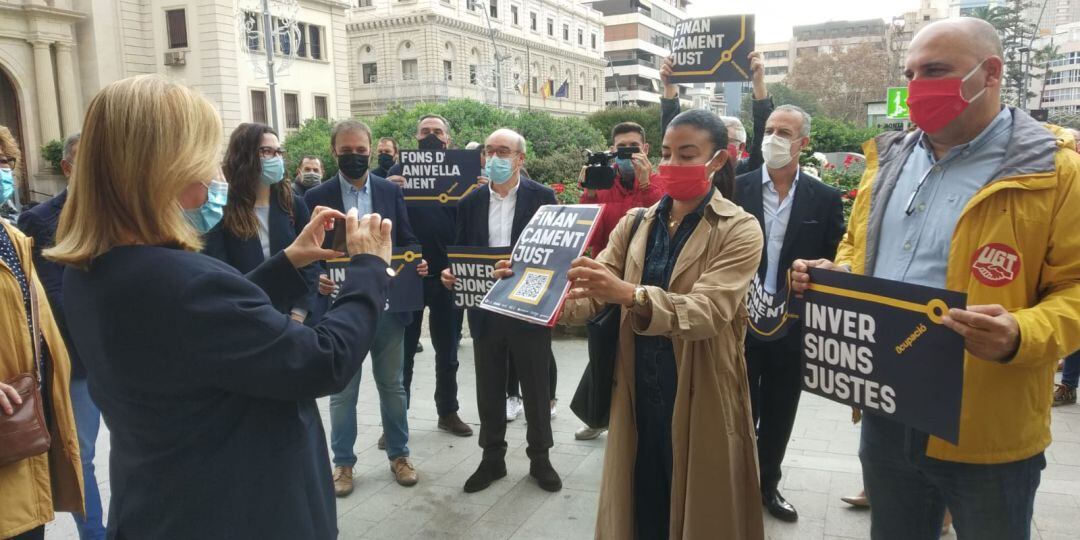 La subdelegada del Gobierno, Araceli Poblador, hace una foto al código QR con el que acceder al manifiesto de la Plataforma per un Finançament Just 