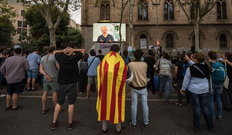 Assange habla frente al estudiantes catalanes a través de una videoconferencia.