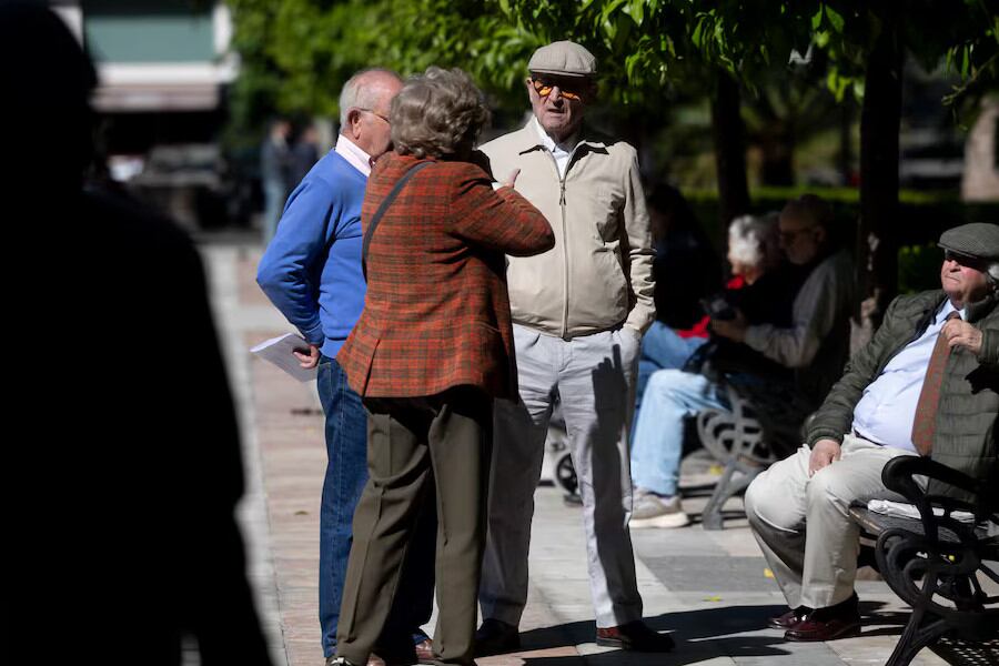 Un grupo de personas mayores conversando en un parque