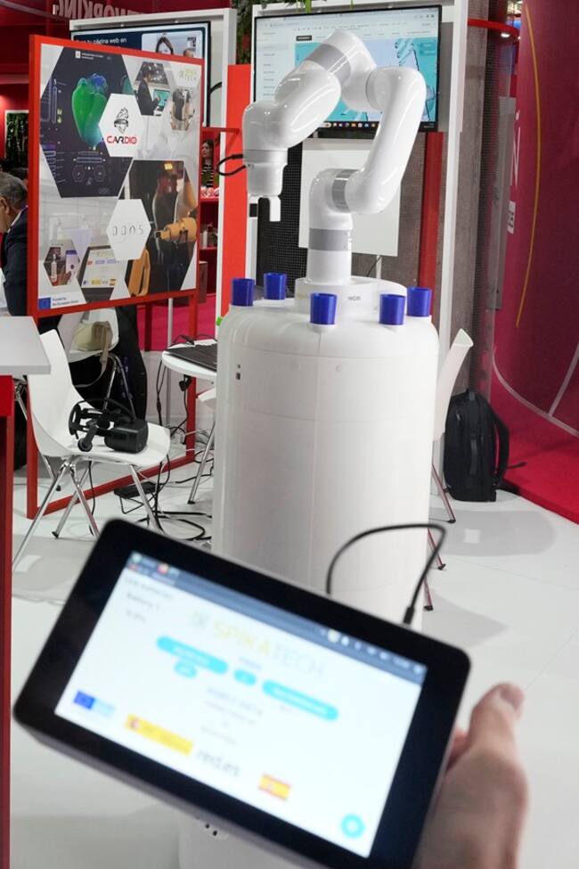 GRAFCAT574. BARCELONA, 28/02/2024.- Un chaleco que permite visualizar el estado de un corazón, una aplicación para manipular en remoto un teléfono móvil, un robot que dispensa medicamentos (en la imagen) o una visita virtual al Estadio Bernabéu son algunas de las novedades que las pymes españolas exhiben en el Pabellón de España del MWC de Barcelona. EFE/Alejandro García