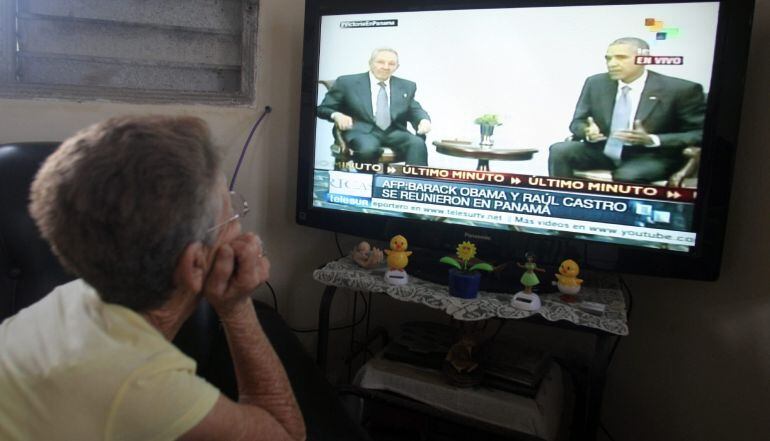 Una mujer mira en televisión las imágenes del encuentro entre los presidente de Cuba, Raúl Castro, y Estados Unidos, Barack Obama.