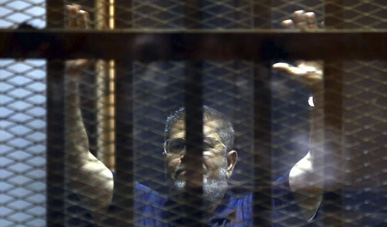 Fotografía de archivo tomada el 2 de junio de 2015 que muestra al expresidente egipcio, Mohamed Mursi, en el interior de una celda durante su juicio en un tribunal de El Cairo (Egipto).