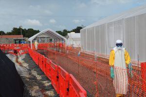 (FILES) -- A file photo taken on October 27, 2014 shows health workers wearing Personal Protective Equipments (PPE) standing outside an Ebola treatment center run by the non-governmental international organization Medecins Sans Frontieres (Doctors without