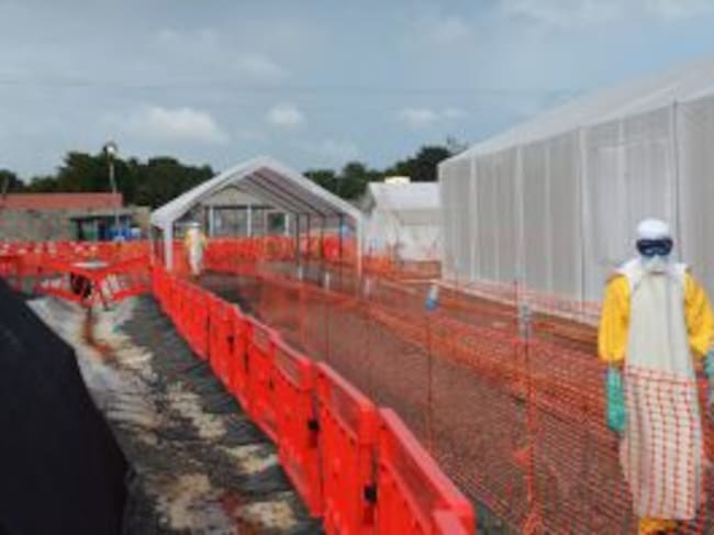 (FILES) -- A file photo taken on October 27, 2014 shows health workers wearing Personal Protective Equipments (PPE) standing outside an Ebola treatment center run by the non-governmental international organization Medecins Sans Frontieres (Doctors without