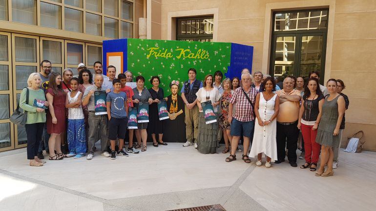 Organización, colaboradores y participantes junto al mural de José Luis Saura sobre Frida Kahlo